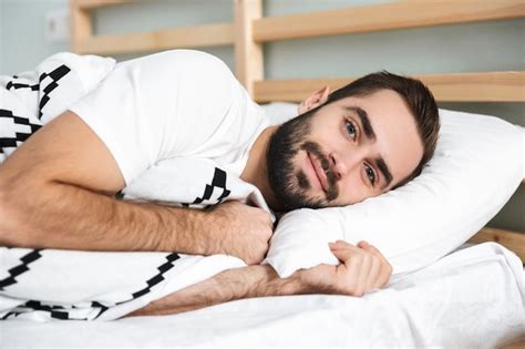 Premium Photo | Handsonme smiling man sleeping on a pillow in bed