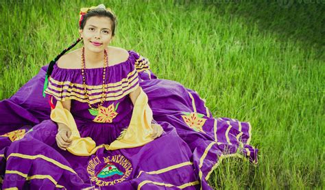 Portrait of Nicaraguan girl in folk costume sitting on the grass, Young