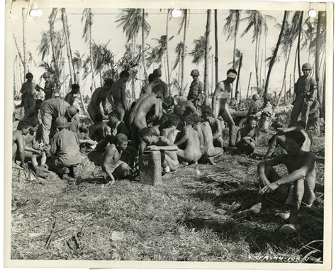 7th Infantry Division military police watch captured Japanese prisoners