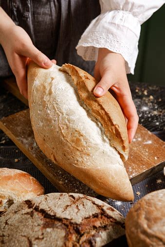 tangan memegang sepotong roti gandum  papan  atas meja gandum hitam
