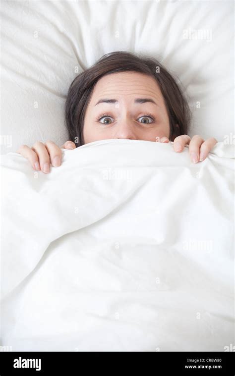 woman hiding  covers  bed stock photo alamy