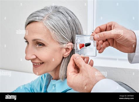 invisible   canal hearing aids doctor demonstrates display stand