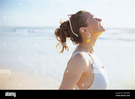 smiling modern woman in white beachwear at the beach relaxing Stock ...