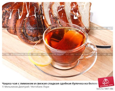 Чашка чая с лимоном и свежая сладкая сдобная булочка на белом фоне ...