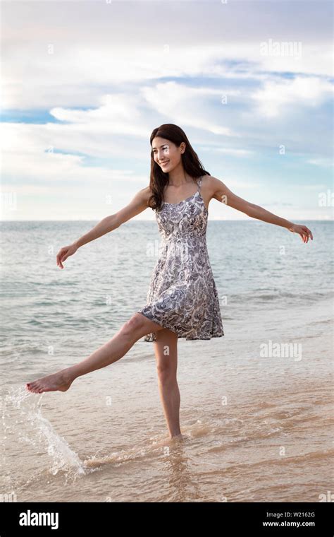 Happy young woman on beach Stock Photo - Alamy