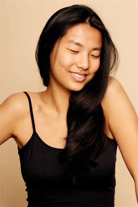 "Young Beautiful Asian Woman Portrait Smiling With Eyes Closed Isolated
