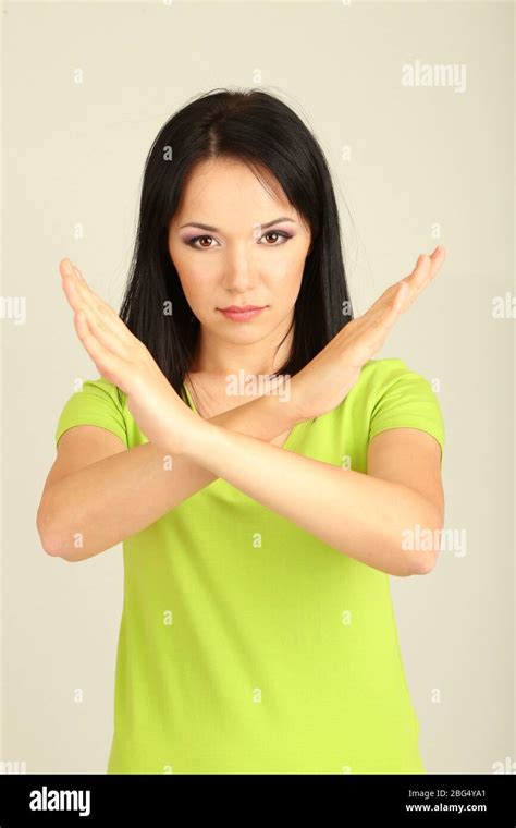 girl showing stop sign  grey background stock photo alamy