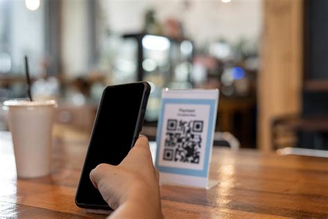 man use smartphone to scan QR code to pay in cafe restaurant with a