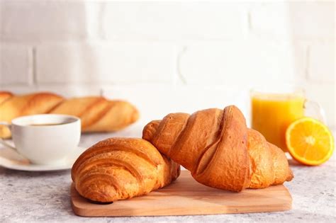 Premium Photo | Delicious french bakery croissants with orange juice orange fruit and coffee on ...