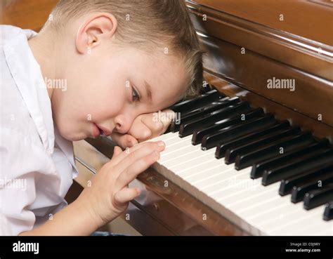 Sad Young Boy with Head on the Piano Stock Photo - Alamy