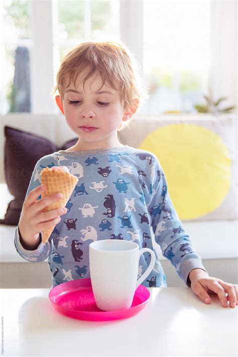 "Boy Wearing Pajamas Seriously Considering The Ice Cream Cone In His