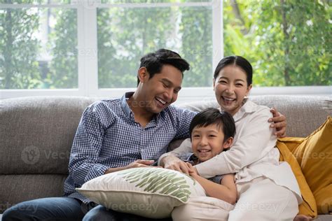 portrait of happy Asian family spending time together on sofa in living
