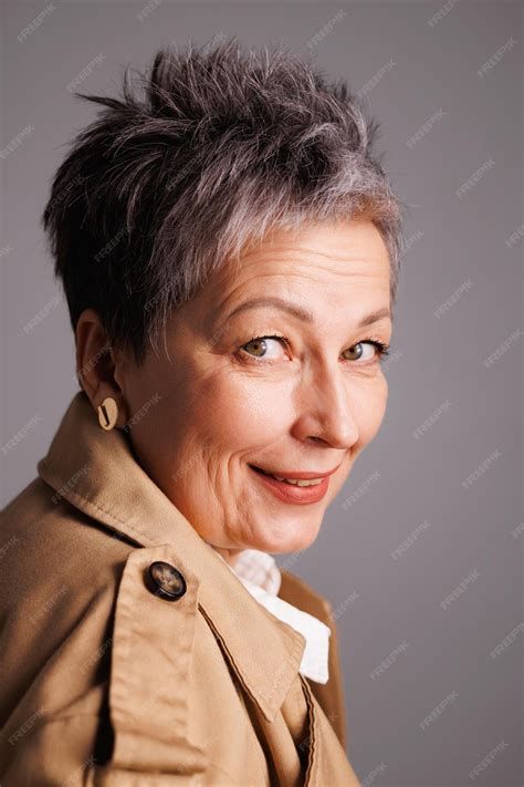 Premium Photo | Smiling and elegant mature woman in trench coat looking