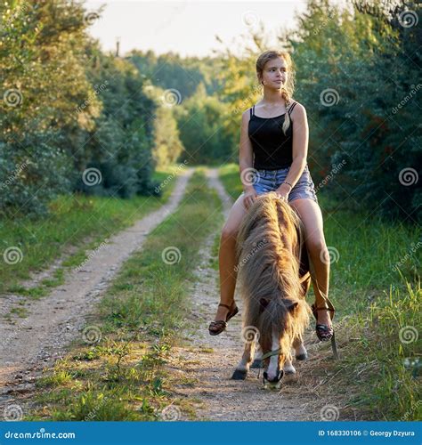 Teenage Girl Riding on a Pony Horse Along a Country Road Stock Photo