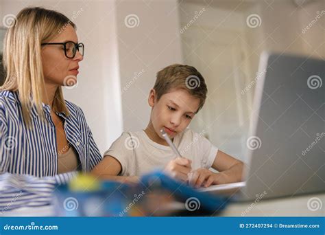 Focused Mom Helping Her Son Doing Homework Studying Online Using Laptop