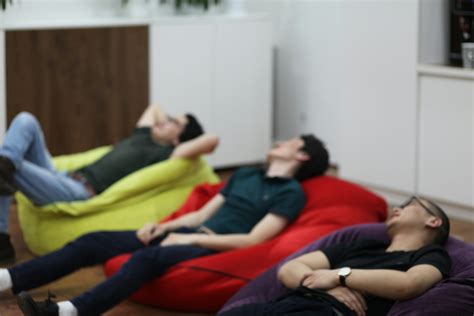 A group of people laying on bean bag chairs photo – Free Person Image