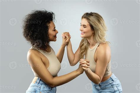 Caucasian and African American women holding hands. Concepts