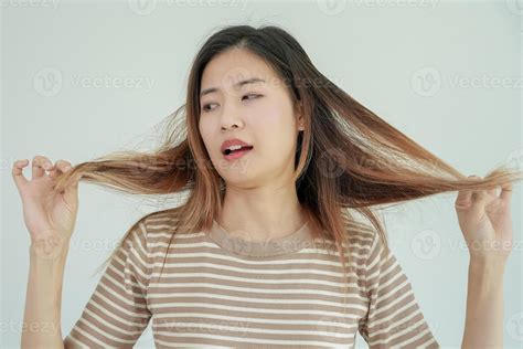 Asian woman very sad and upset looking at damaged hair, hair loss, hair