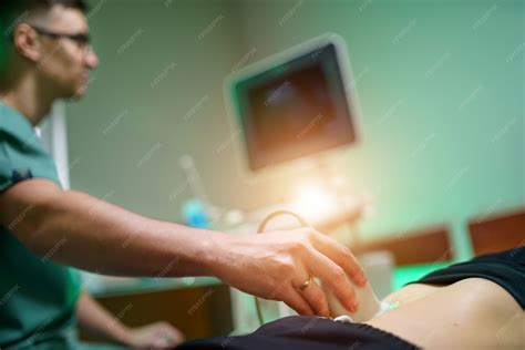Medico Que Faz Ultrassom - Um jovem médico faz a um paciente um ultrassom da cavidade abdominal ...