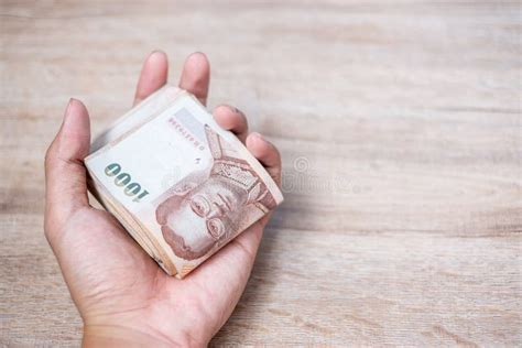 businessman hand holding thai baht banknote stack business money