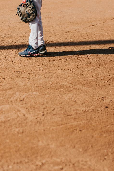 A baseball player stands ready on the dirt field. photo – Free People