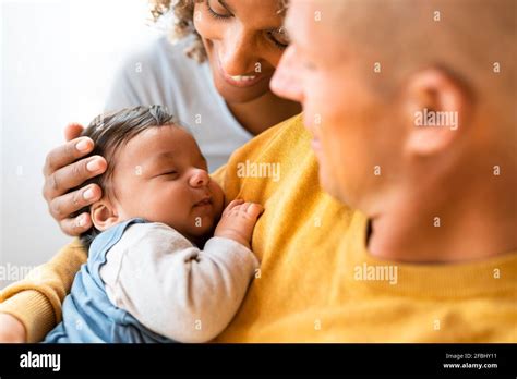 Parents looking at cute sleeping baby at home Stock Photo - Alamy