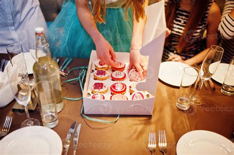 Happy bride receiving cupcakes as a present from her bridesmaids