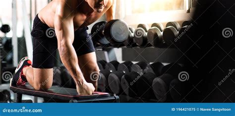 Young Man Naked Bodybuilder Exercising Lifting with Dumbbell at Gym. .Gym Equipment and Sport