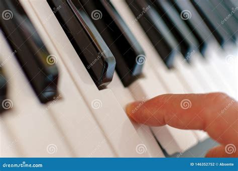 A Finger Presses a Key on a Piano Stock Photo - Image of musical ...