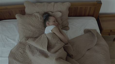 Happy young woman between 30 and 35 years old stays in her bed