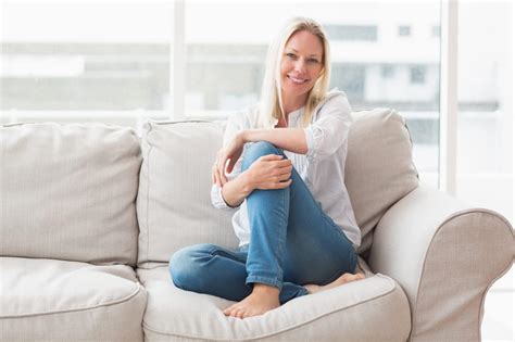 Portrait of happy woman sitting on sofa | All Brite Cleaning & Restoration