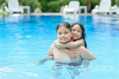 Brother and sister play water in swimming pool 23313100 Stock Photo at