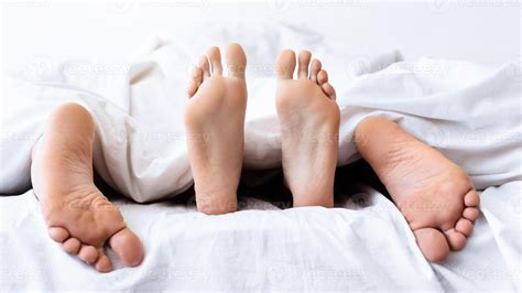 Sex Concept. Male And Female Feet Under Blanket, Conceptual Shot