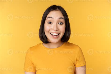 Close up portrait of asian girl showing surprised reaction, raising