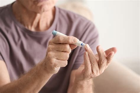 Glicemia Em Idosos - Homem idoso com diabetes medindo o nível de açúcar no sangue em casa ...