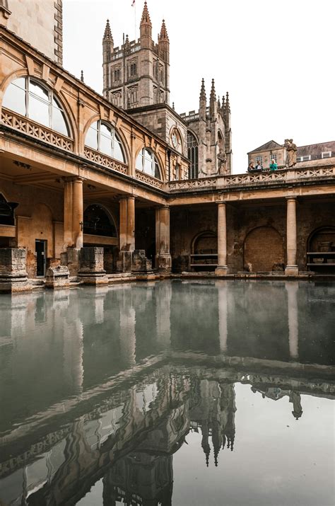 Old temple facade reflecting in Roman Baths in England · Free Stock Photo
