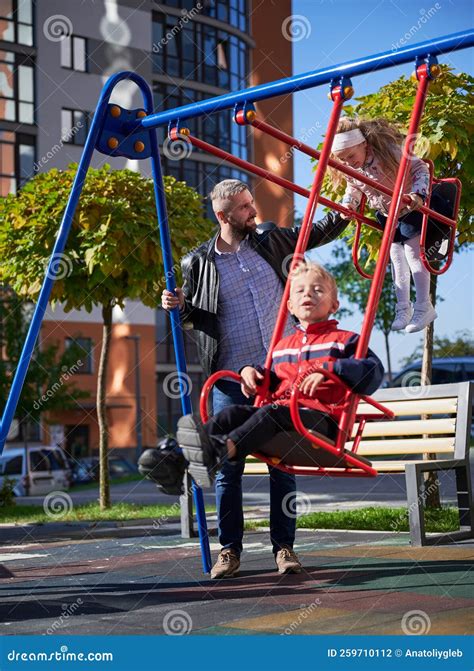 dad swinging cute children  swings  playground  autumn stock