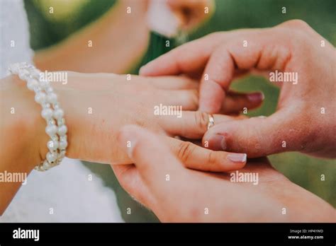 picture  man putting wedding ring  woman hand stock photo alamy