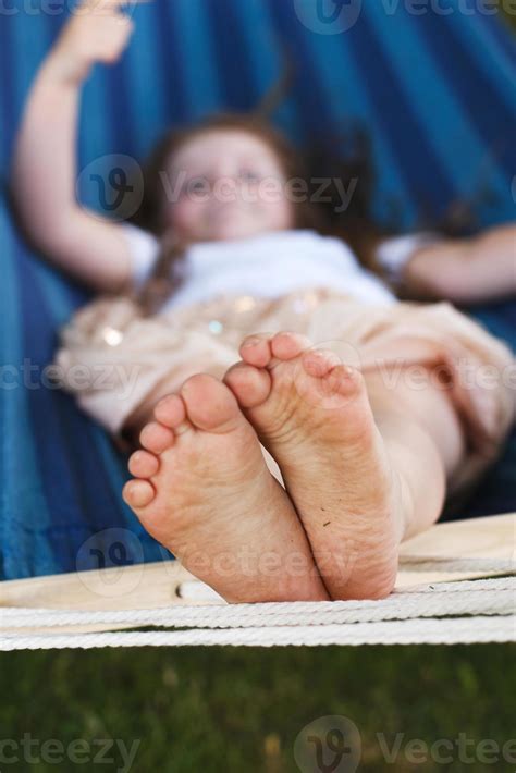 closeup   girls feet relaxing   blue hammock