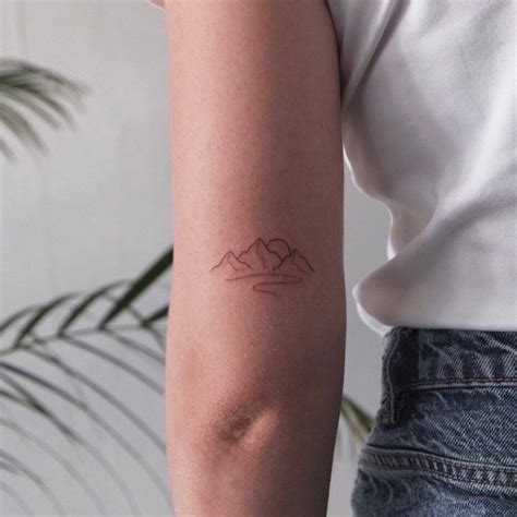 Minimalist mountain tattoo on the tricep.