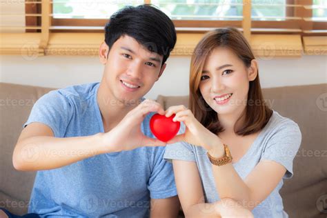 hermoso retrato joven pareja asiática gesto sosteniendo la forma del