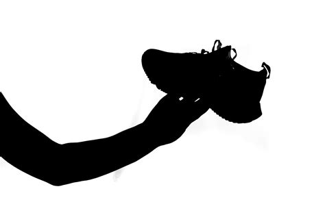 man's hand holding a running shoe on a white background. Ideas for