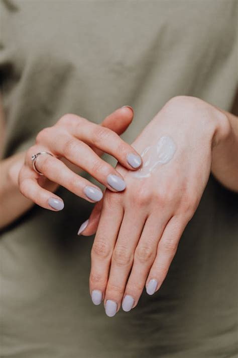 Crop woman with ring applying hand cream · Free Stock Photo