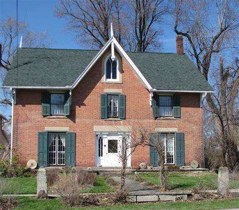 brick house with green shutters - Monroe Perrin