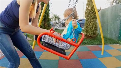 mother swinging  happy child boy   street swing  playground