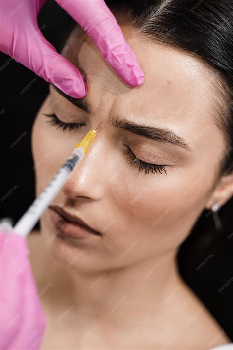 Premium Photo | Beautician is injecting botulinum toxin to correct
