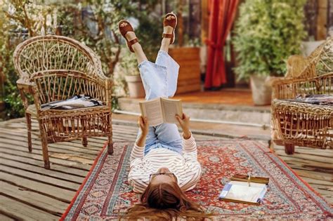 Premium Photo | Girl student reading a book lying on the floor on a carpet in vintage style