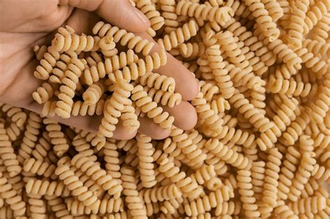 Ручная заливка пасты из кукурузной муки без глютена спиральные сырые ...