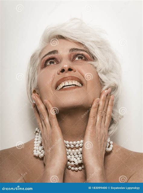 Nude Senior Woman Toothy Smiling Touching Her Face with Her Hands