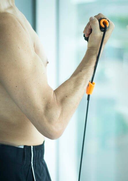 Premium Photo | Midsection of shirtless man stretching resistance band ...